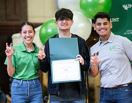 Student posing with UNT staff