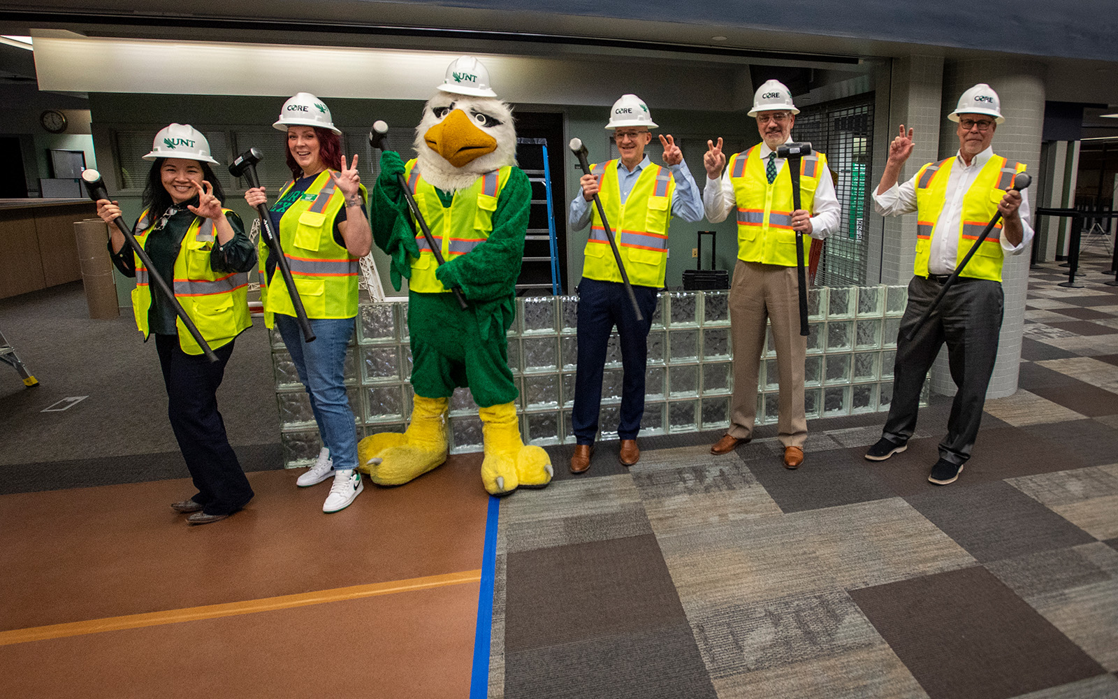 President Smatresk stands with Scrappy and others at the demolition site with sledgehammers and making the eagle claw gesture